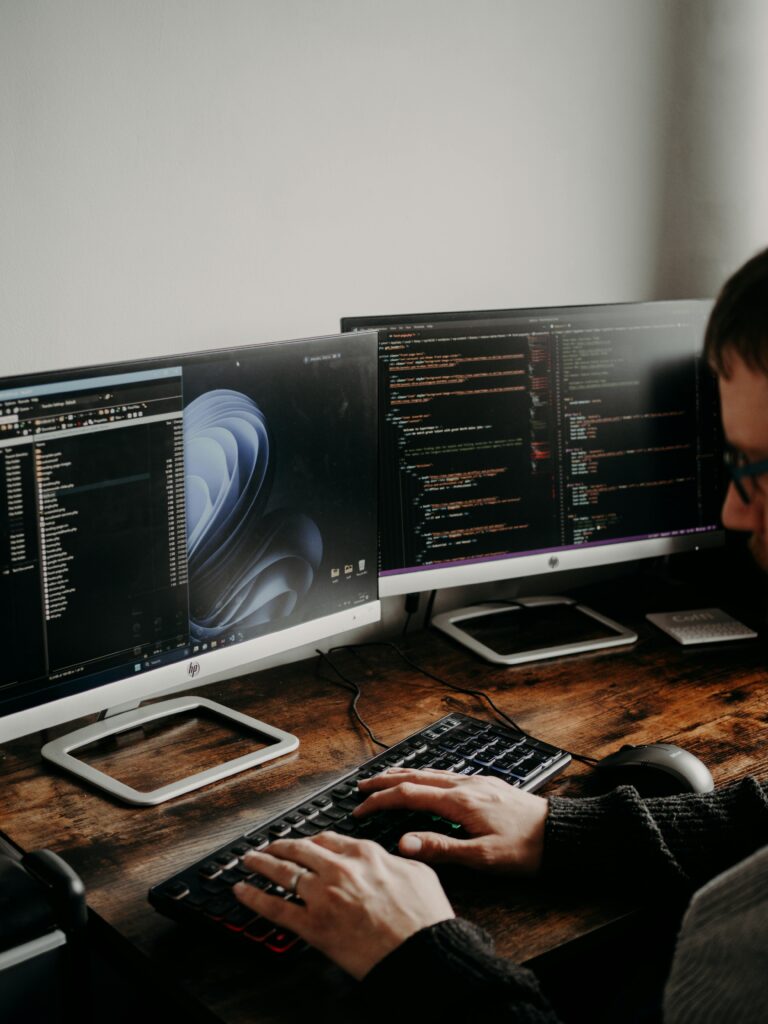Pourquoi faire appel à un web designer ? 1 un homme assis à un bureau avec plusieurs écrans d'ordinateur